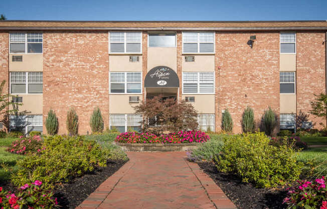 A brick building with a garden in front.