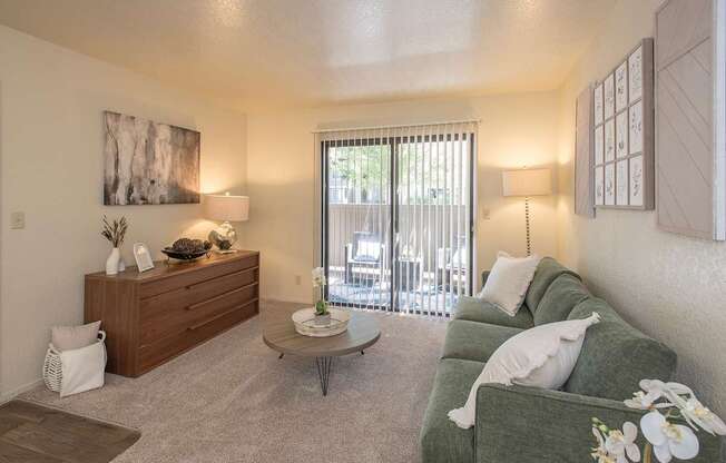 A living room with a green couch and a wooden dresser at Zinfandel Village Apartments, California, 95670