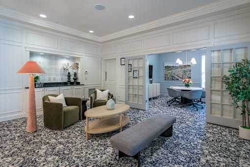 A living room with a grey sofa, a wooden coffee table, and a large window.