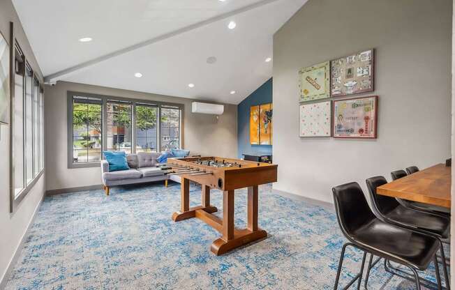A room with a blue carpet and a wooden table.