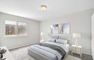 A bedroom with a large bed and two lamps.