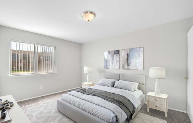 A bedroom with a large bed and two lamps.