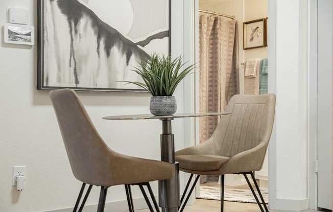 a dining room table with two chairs and a plant on it