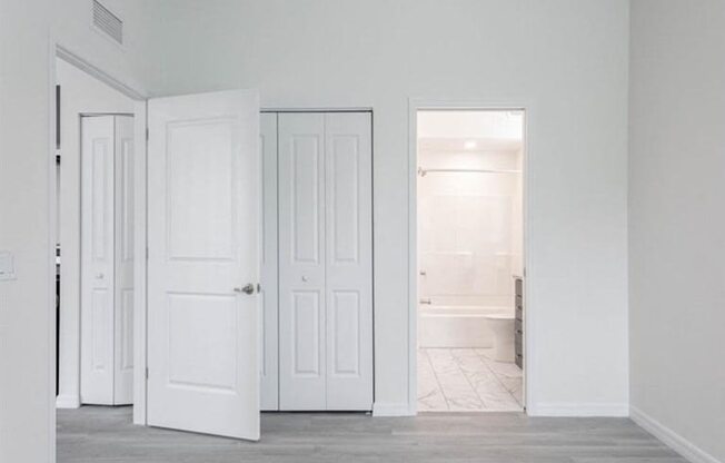 A room with white doors and a grey floor.