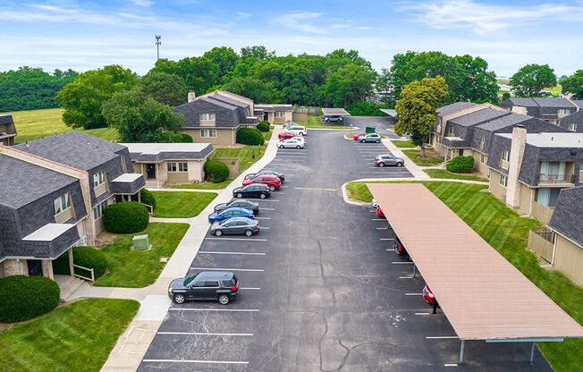 an aerial view of a neighborhood with cars parked in a parking lot