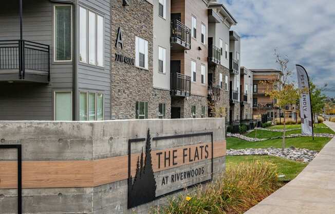 the flats at evergreen apartments sign in front of apartments