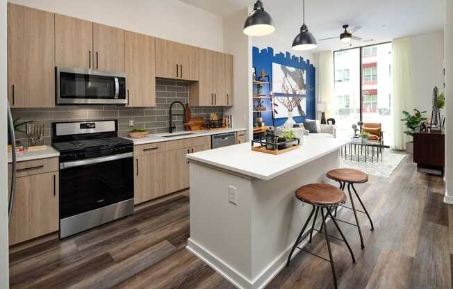 a kitchen with a large white island with three stools in front of it