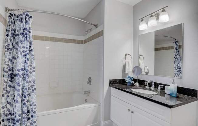 Bathroom with faux hardwood floors, white trim, neutral walls, and soaking tub.