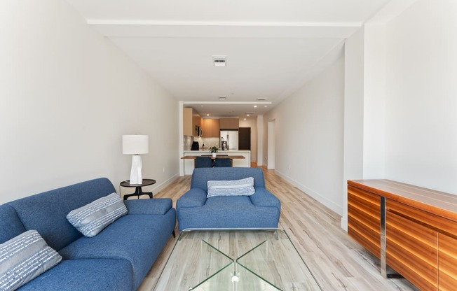 a living room with blue couches and a glass table