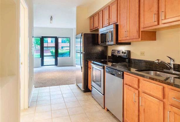 a kitchen with wooden cabinets and a sink and a refrigerator