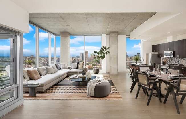 a living room with a couch and a table in front of windows