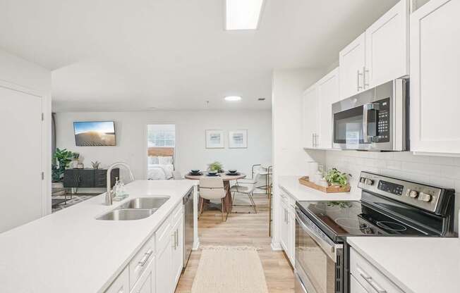 A modern kitchen with white cabinets and stainless steel appliances.
