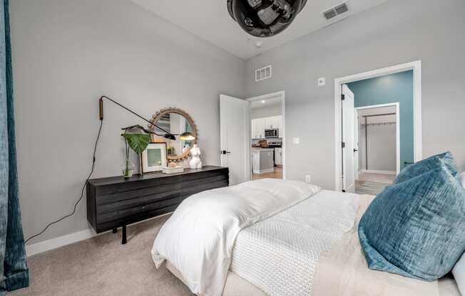 a bedroom with grey walls and a white bed