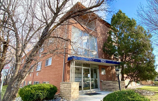 Welcome to your new home! This charming brick exterior offers a cozy facade framed by beautiful trees.
