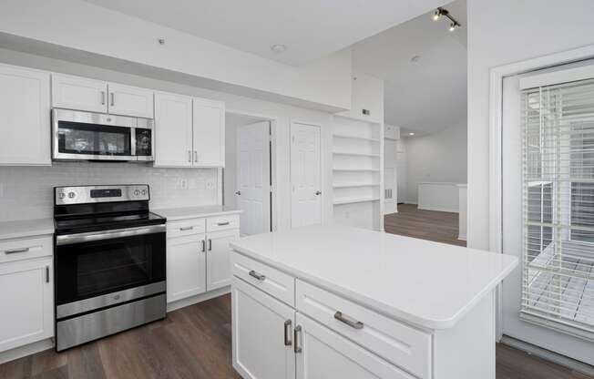 a kitchen with white cabinets and a large white island