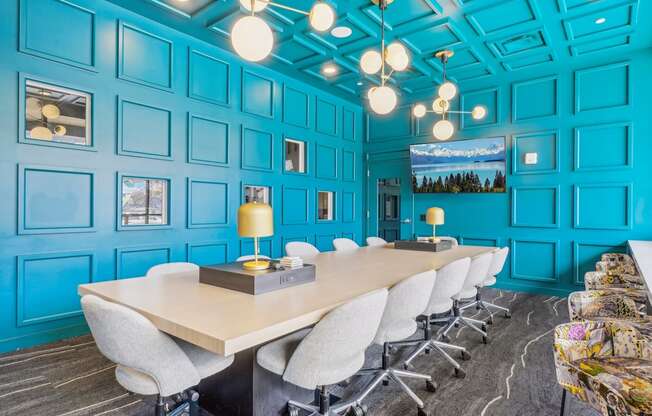 a conference room with blue walls and a long table with chairs