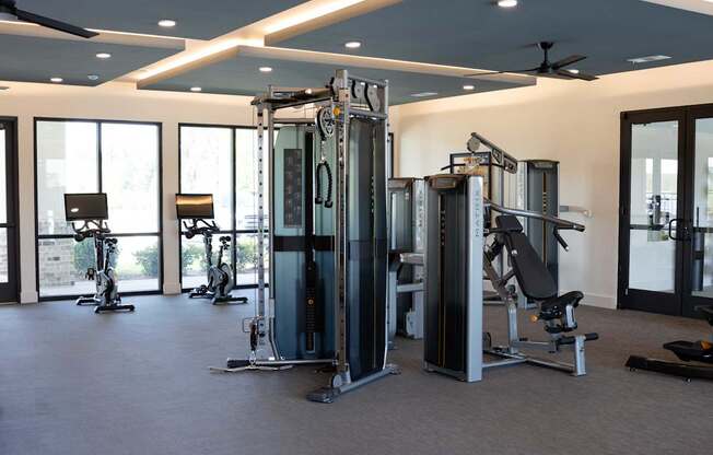 A gym with a variety of equipment including a squat rack, a leg press machine, and a bench press.