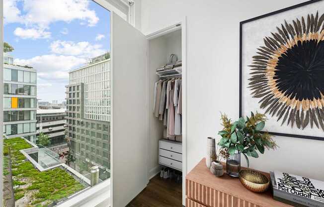 A room with a view of a green rooftop garden and a framed picture on the wall.