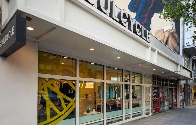 A storefront with a large yellow and black window and a sign that reads Soulcycle.