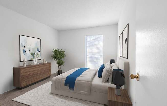 A bedroom with a bed, nightstand, and a plant.
