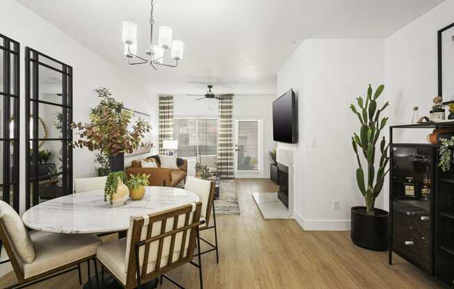 a living room and dining room with a table and chairs