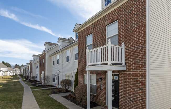 a row of brick apartments with a balcony and a sidewalk at Traditions at Slate Ridge, Reynoldsburg, OH 43068