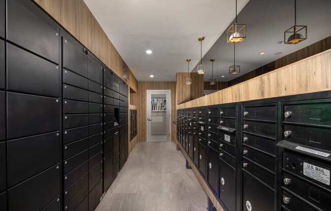 a long hallway with black mailboxes and wooden walls