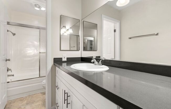 Apartments For Rent In Culver City, CA - Parkway Plaza - Bathroom With Dark Counter Tops And White Cabinetry With Toliet And Shower Separate From Sink And Vanity