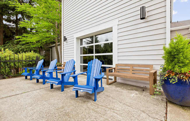 A set of blue chairs are arranged on a patio.