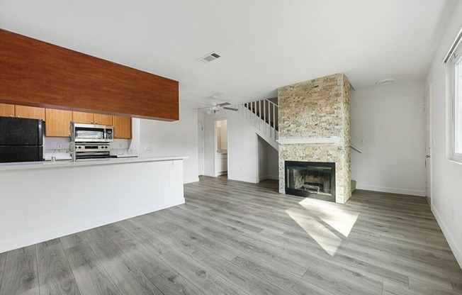 living room with a fireplace  and kitchen with vinyl wood like flooring and stainless steel appliances