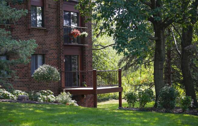 a wooden deck in front of a brick house