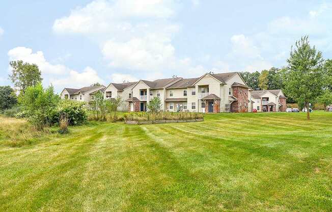 A row of houses with a green lawn in front.