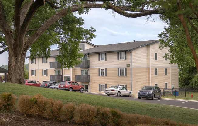 a large apartment building with cars parked in front of it