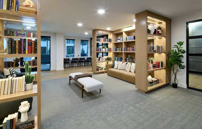 A room with a grey carpet and bookshelves filled with books.