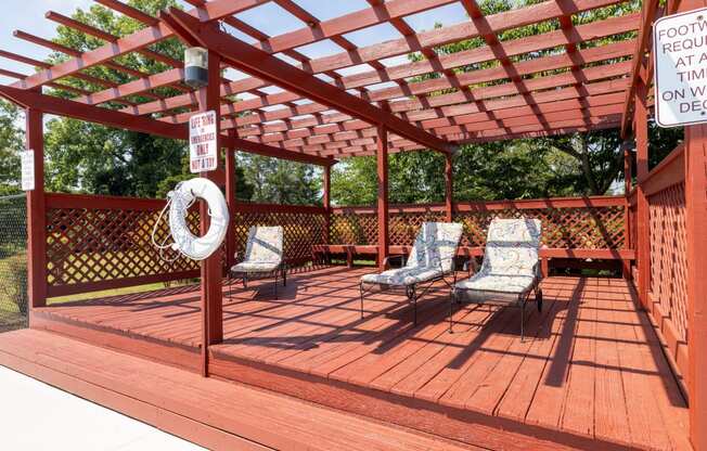 a covered deck with chairs and a pergola