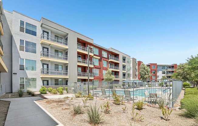 A modern apartment complex with a pool in the courtyard.