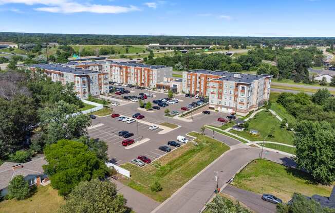 an aerial view of a parking lot in front of several apartment buildings