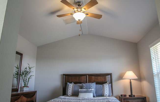 a bedroom with a ceiling fan and window at Village of Cottonwood Springs in El Paso