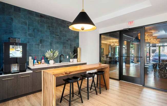 a kitchen with a wooden bar and black stools