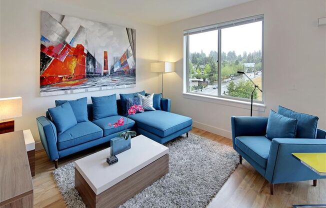 a living room with blue furniture and a large window