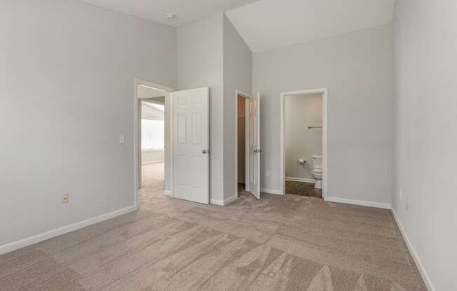 a spacious living room with carpet and a door to a bathroom