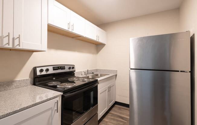 a kitchen with white cabinets and stainless steel appliances and a refrigerator