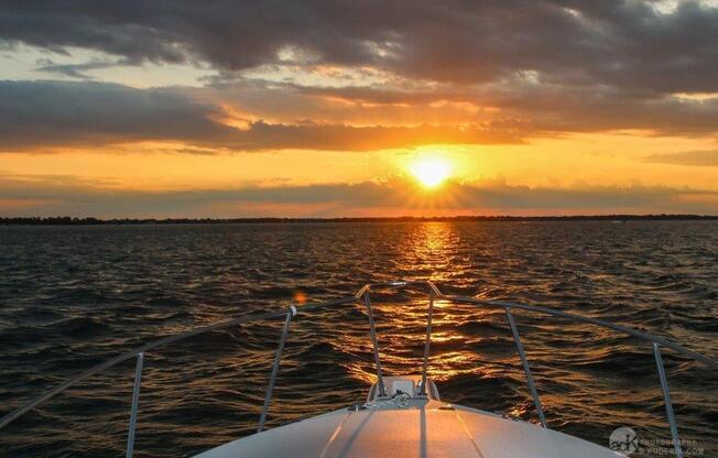 a boat in the water with a sunset in the background