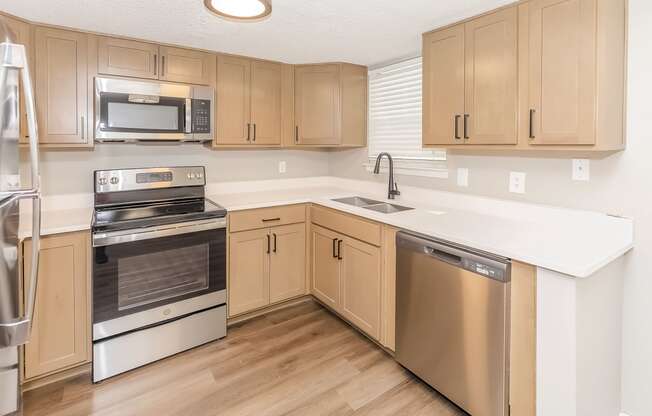 a kitchen with wooden cabinets and stainless steel appliances
