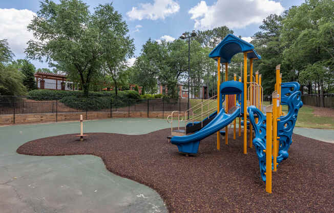 a playground at a park with a blue and yellow slide