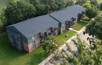 A large building with a grey roof and a green lawn in front.