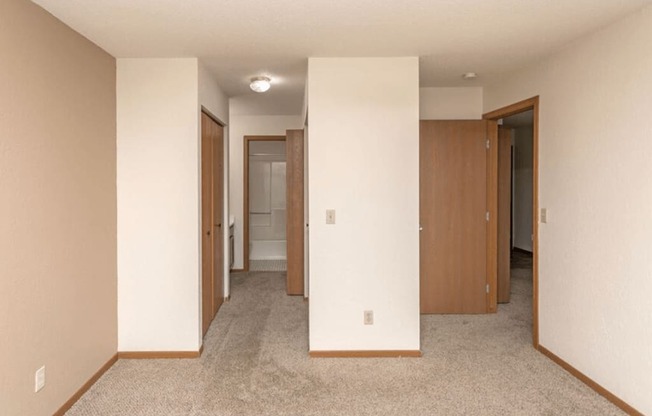 an empty living room with white walls and doors