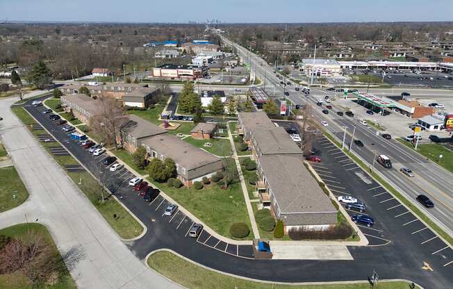 an aerial view of a parking lot with several buildings and a highway