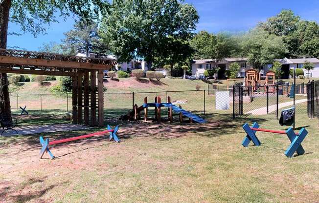 a playground with a wooden structure and a blue and red swing set