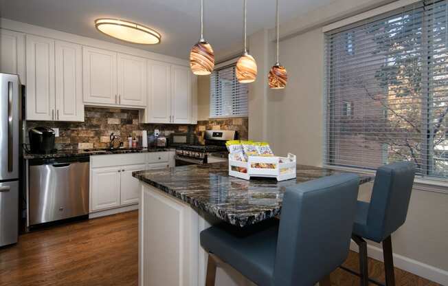 a kitchen with white cabinets and a granite counter top